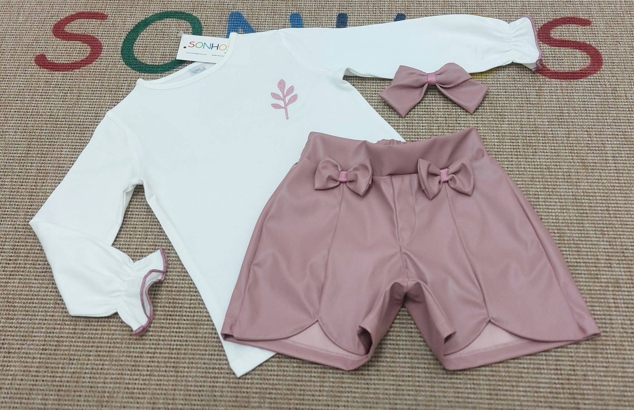 Conjunto elegante de pantalón polipiel rosa con lazos